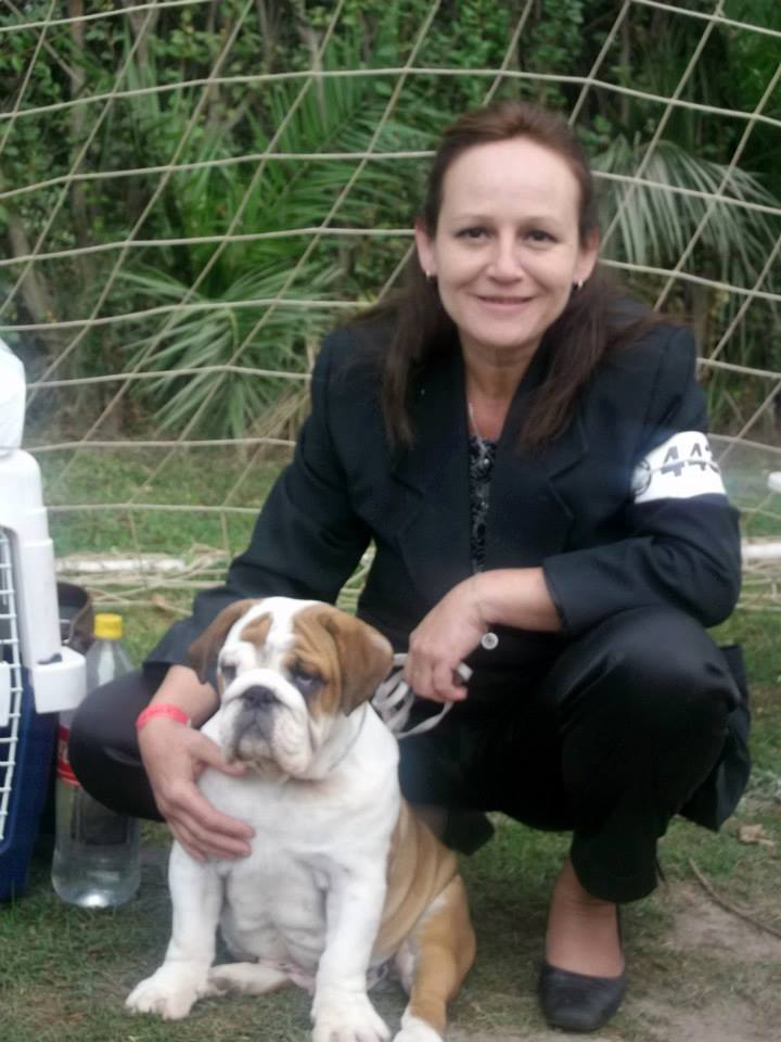 karen vestida formalmente de handler con su numero de participación tomado en su brazo y junto a una cachorra bulldog inglés