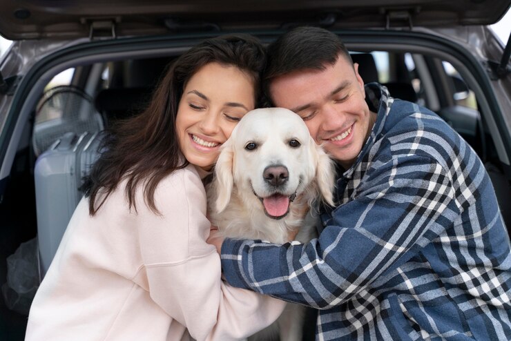 pareja feliz abrazando a su golden retriever sentados en la parte trasera de su auto donde estan de vacaciones 