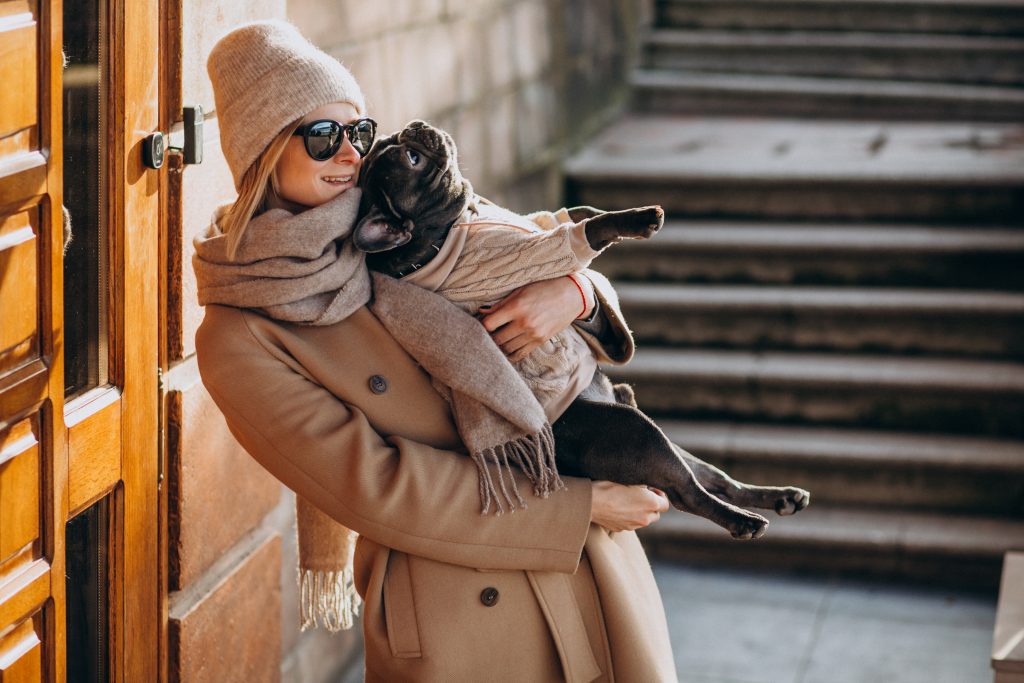 Woman withg her pet french bulldog walking out